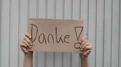 hochgehaltenes Schild mit dem Wort Danke