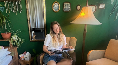 Lilly sitzt in ihrem WG Zimmer auf einem Sessel, den sie an der Straße gefunden hat