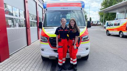 Frauen vor einem Rettungswagen.