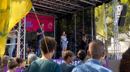 eine Fridays for Future Demonstration in Stuttgart. Auf der Bühne steht eine junge Frau uns spricht.