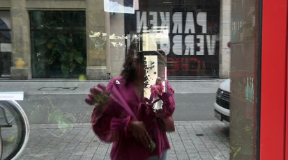 Ich stehe vor einem Blumenladen mit selbstgekaufen Blumen in der Hand. 
