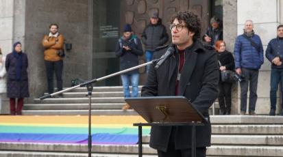 Alon Bindes, ein Mann mit dunklen Locken, Brille und schwarzem Mantel hält eine Rede am Stuttgarter Marktplatz.