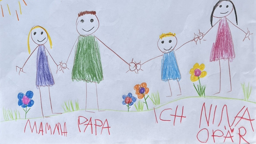 Eine Kinderzeichnung mit zwei Eltern, einem Kind und einer weiteren Person (das Au-pair), die Händchen halten, auf einer Blumenwiese
