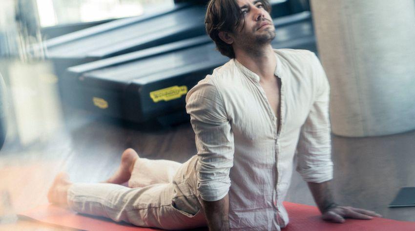 Mann beim Dehnen auf einer Yogamatte