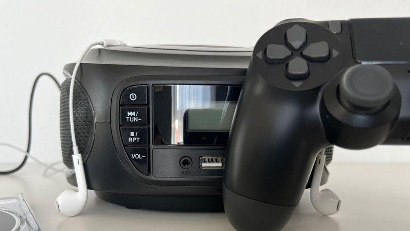 Ein CD Player mit einem Controller und Kopfhörer davor.