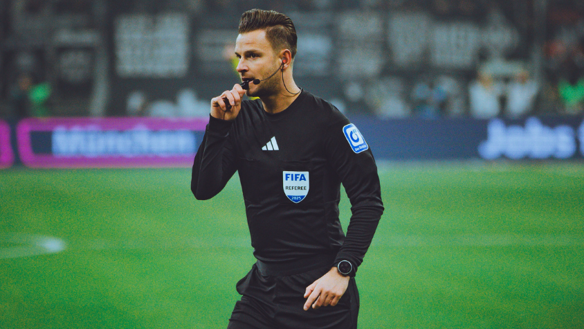 Schiedsrichter Daniel Schlager mit seiner Pfeife im Mund