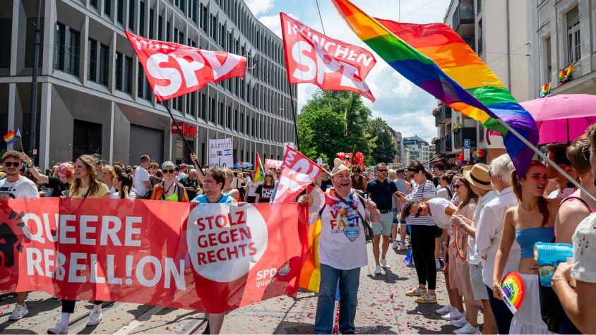 Eine Gruppe Menschen hält ein SPD-Banner und SPD-Fahnen auf dem CSD.