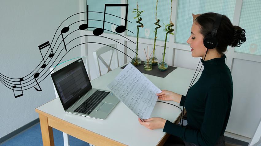 Eine Frau singt allein vor einem Laptop.