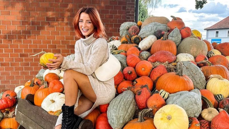 Woman on pumpkins in October.