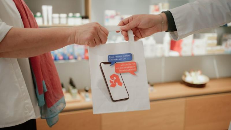 Apothekerin übergibt Patientin eine Tüte mit der Abnehmspritze