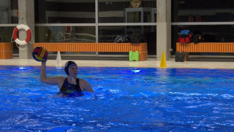 Eine Frau hält einen Wasserball in der Hand