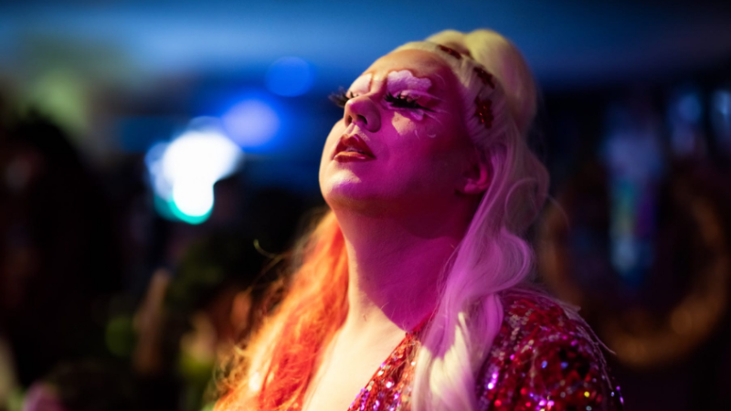 Drag Queen mit ausgefallenem Make-Up genießt den Moment mit geschlossenen Augen