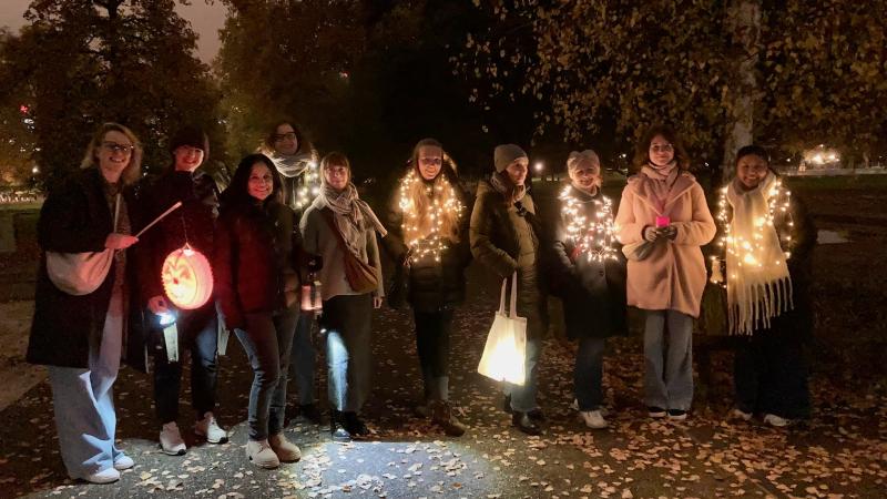 Eine Gruppe Frauen bei Dämmerung mit Laternen und Lichterketten.