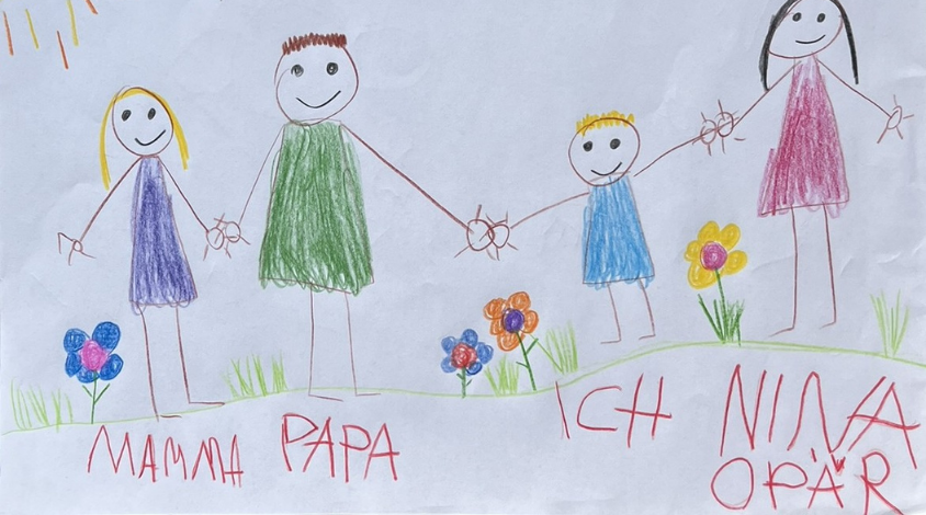 Eine Kinderzeichnung mit zwei Eltern, einem Kind und einer weiteren Person (das Au-pair), die Händchen halten, auf einer Blumenwiese.